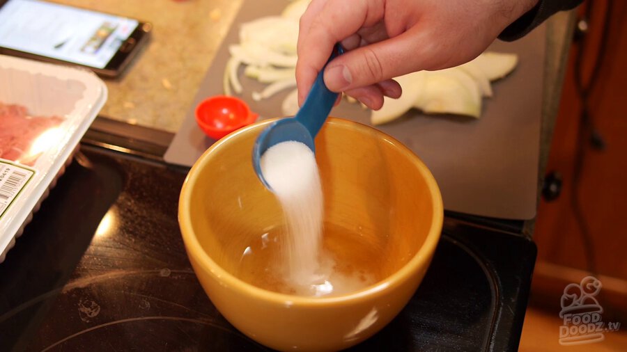 Sugar is measured into bowl with mirin and dashi powder