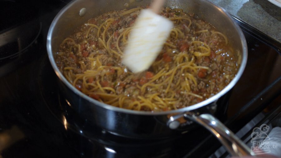 Large spoon stirs pot of taco spaghetti