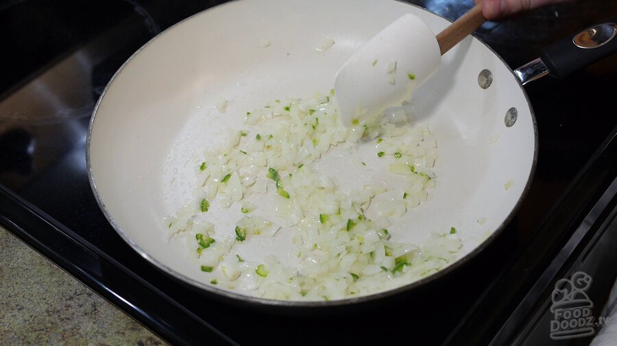 Onion turns translucent in non-stick skillet with chopped serrano pepper