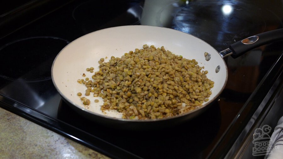 Boiled lentils are added to taco seasoning, onions, and serrano peppers in skillet