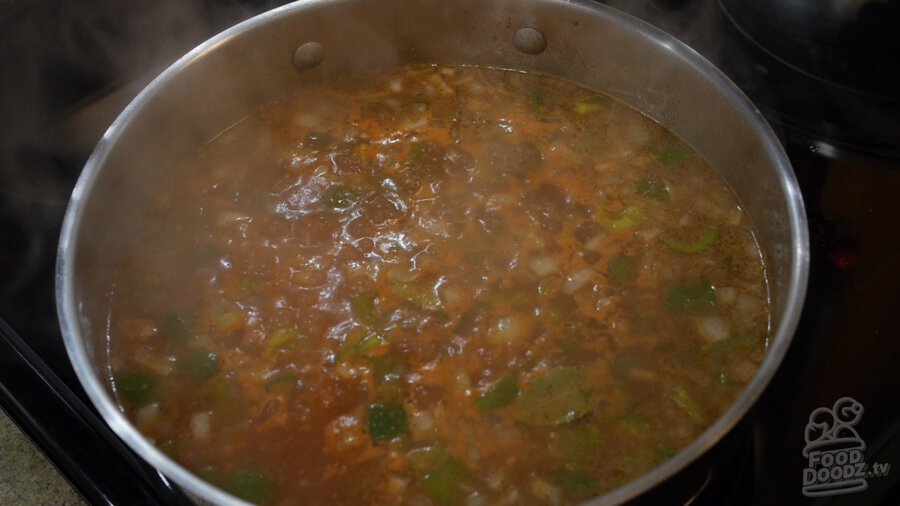 tomato sauce, vegetable broth, green bell pepper, onion, and toasted rice mixture is brought to a boil