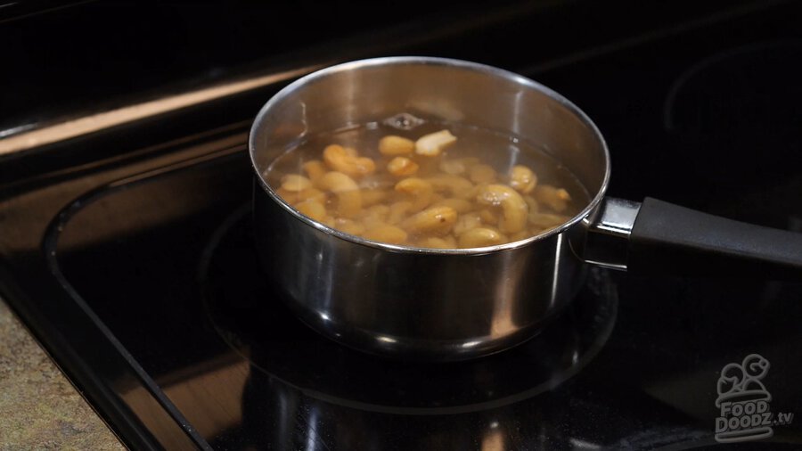 Cashews boiling in small pot of water