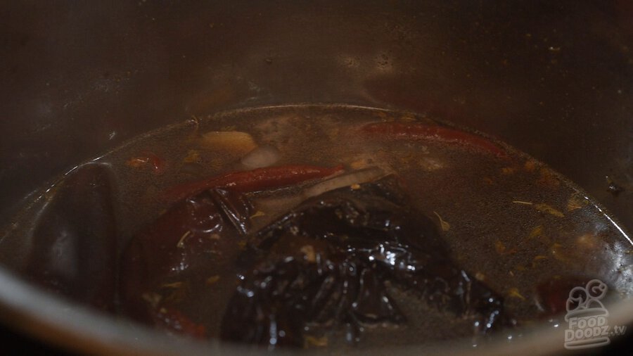 Dried chilies rehydrated in bowl of water (New Mexico Chiles, Ancho, Arbol)