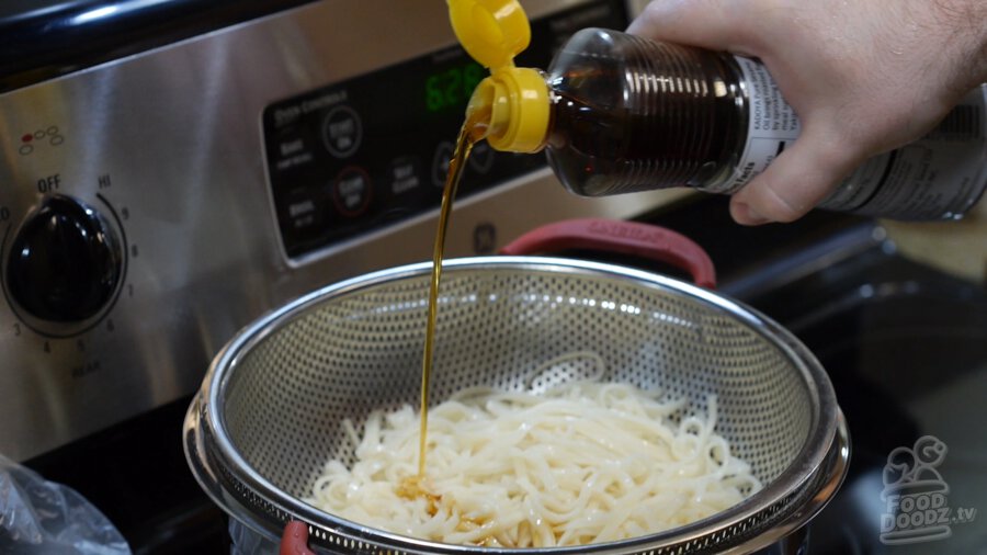 Sesame oil being poured over noodles