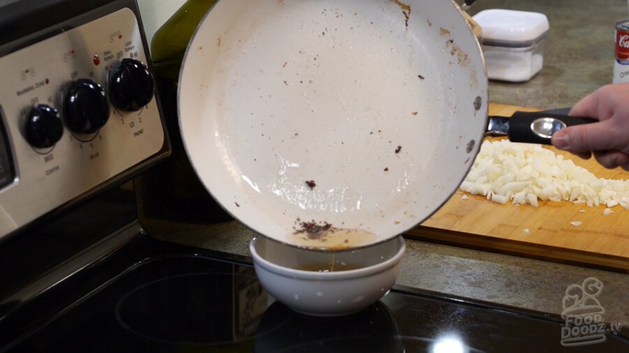 Draining bacon grease into a bowl