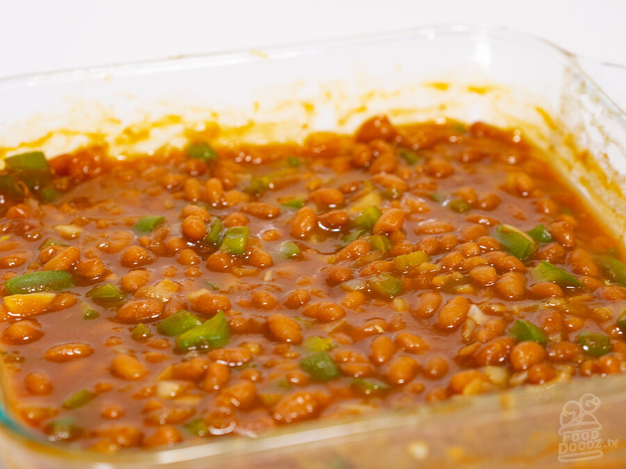 A big steaming baking dish full of reddish brown America's favorite get-together food, baked beans. Mom's world famous baked beans.