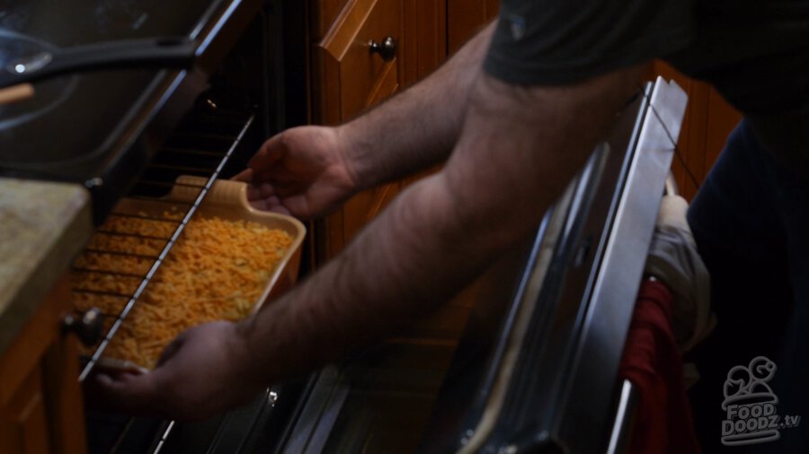 Vegan hashbrown casserole being placed in the oven