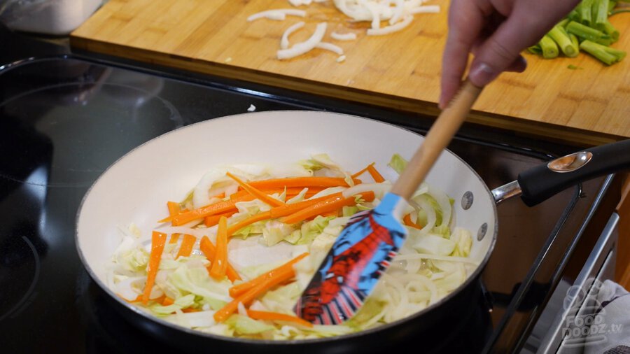 carrot, onion, and cabbage added to hot pan 