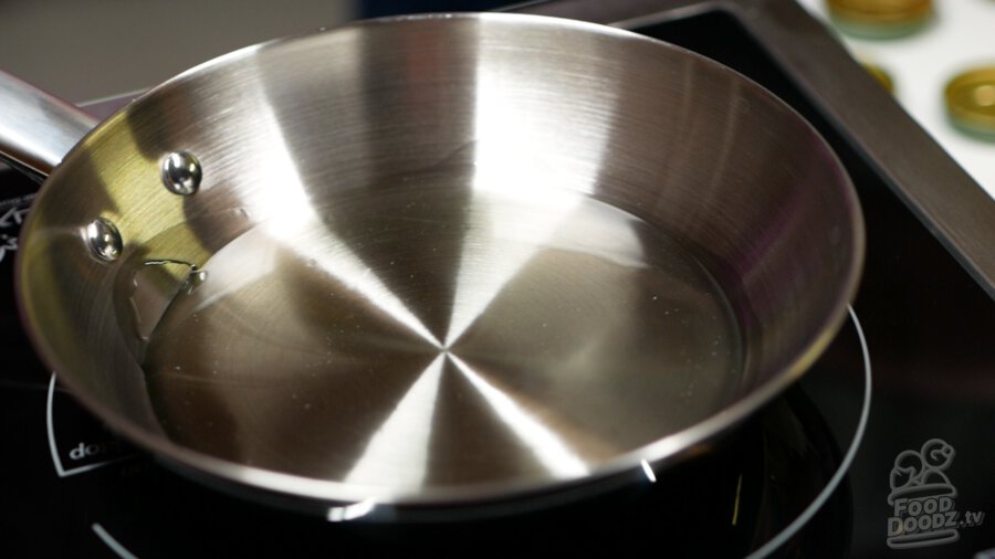 Heating up 1/4 cup of vegetable oil in a small saute pan