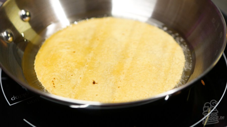 A tortilla frying in the small saute pan