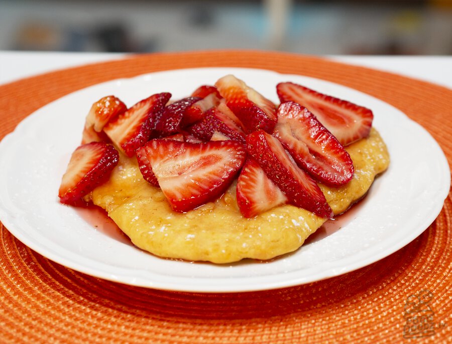 Indian (native american) fry bread topped with juicy sliced strawberries and powdered sugar!