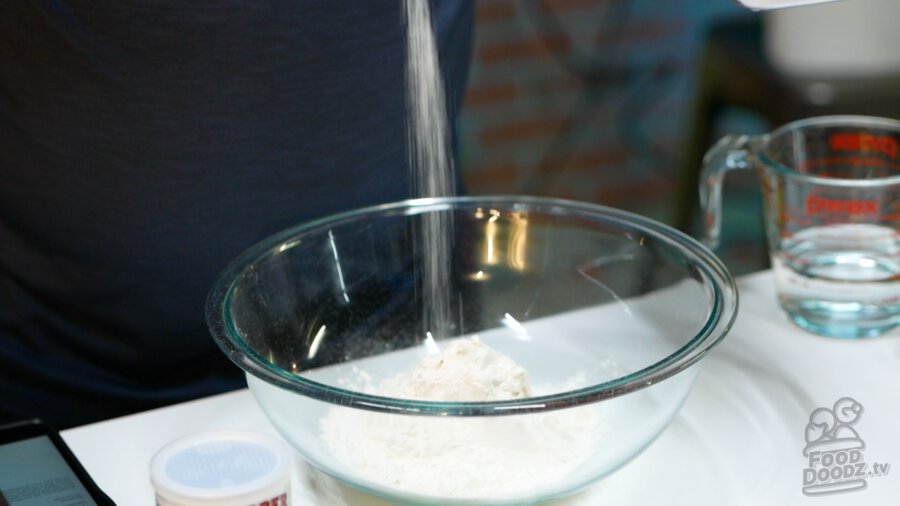Adding salt to flour in bowl