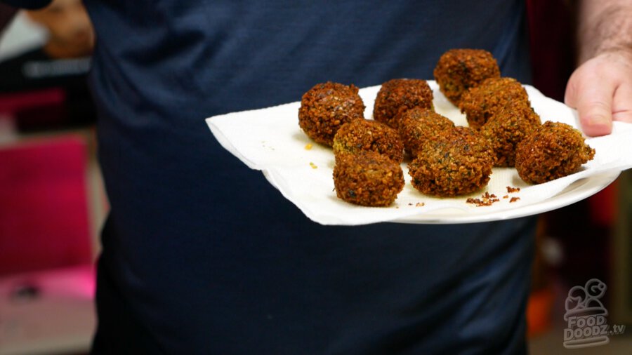 Finished falafels placed onto a paper towel lined plate