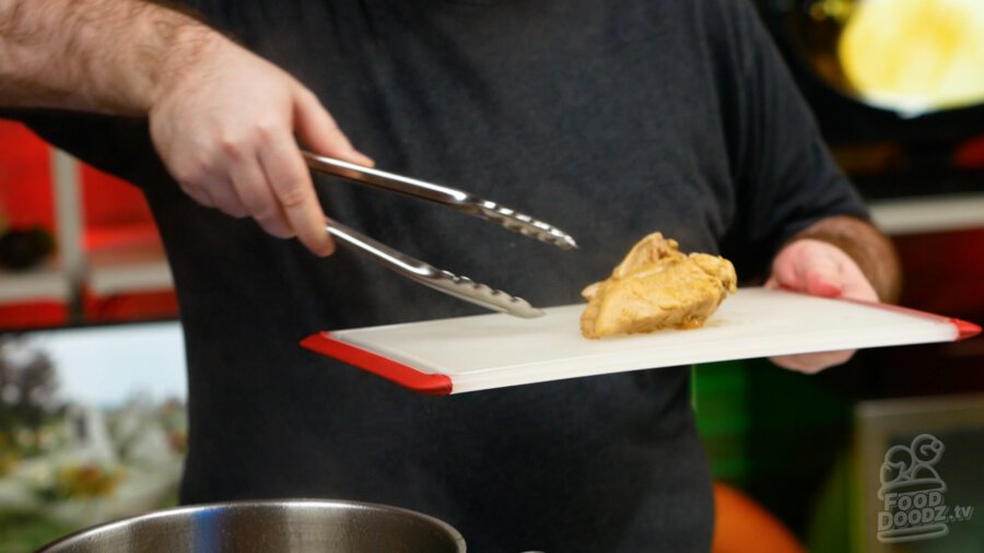 Removing the chicken to a cutting board.