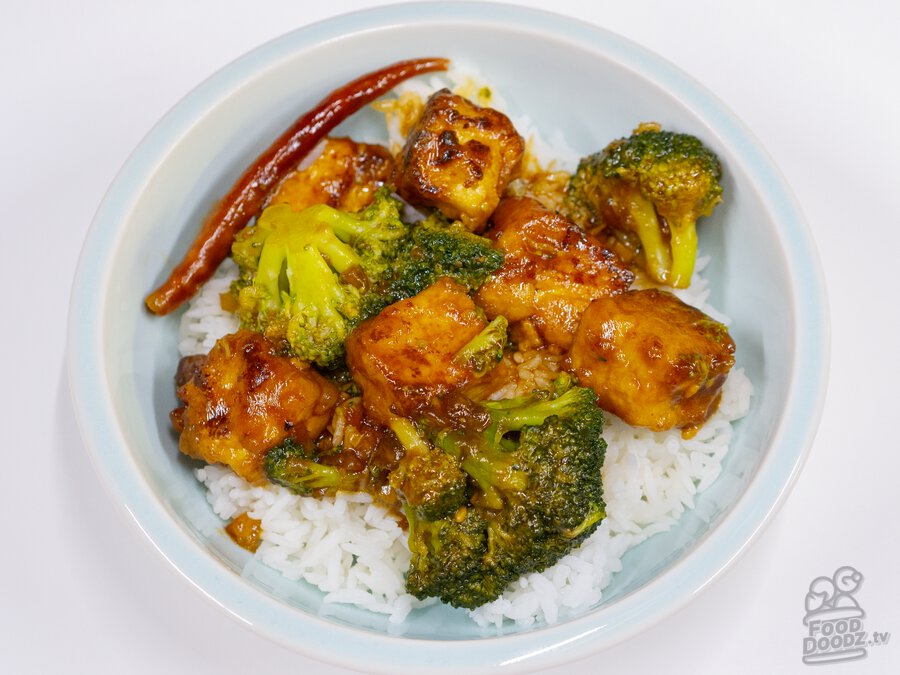 A big bowl of sweet and spicy General Tso's Tofu on top of white rice.