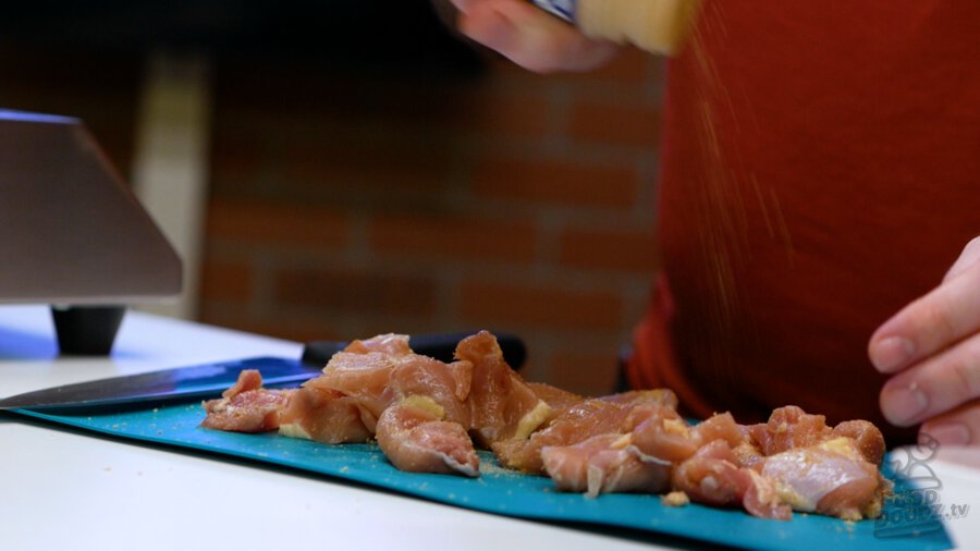 Cut up chicken thighs being seasoned with adobo seasoning