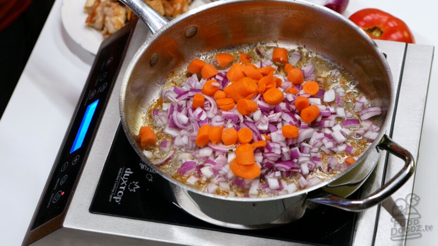 Adding onion and carrots to pan
