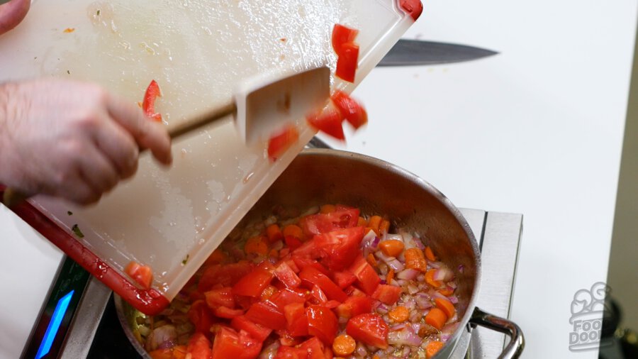 Adding tomato pieces to the pan