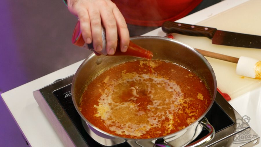 adding hot sauce to pan