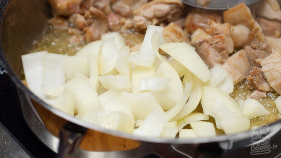 Adding sliced onion to pan