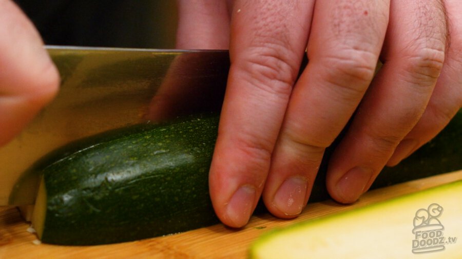 slicing zucchini half lengthwise