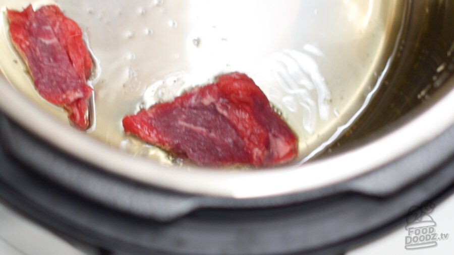 adding seasoned stew meat into pressure cooker
