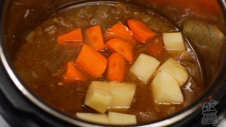 adding potatoes and carrots to pressure cooker