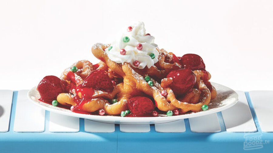 IHOP golden oh what funnel cakes toped with powered sugar, glazed strawberries, whipped topping, and red and green elf sprinkles