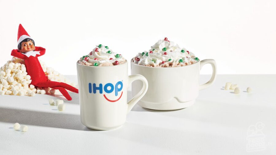 IHOP Merry Marshmallow Hot Chocolate flavored with toasted marshmallow syrup and topped with whipped topping and red and green elf sprinkles