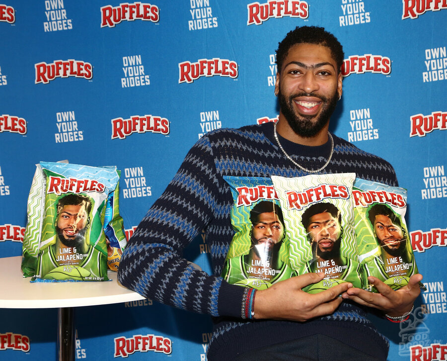 Anthony Davis at Lime & Jalapeno Ruffles chips launch event holding bags of Ruffles chips