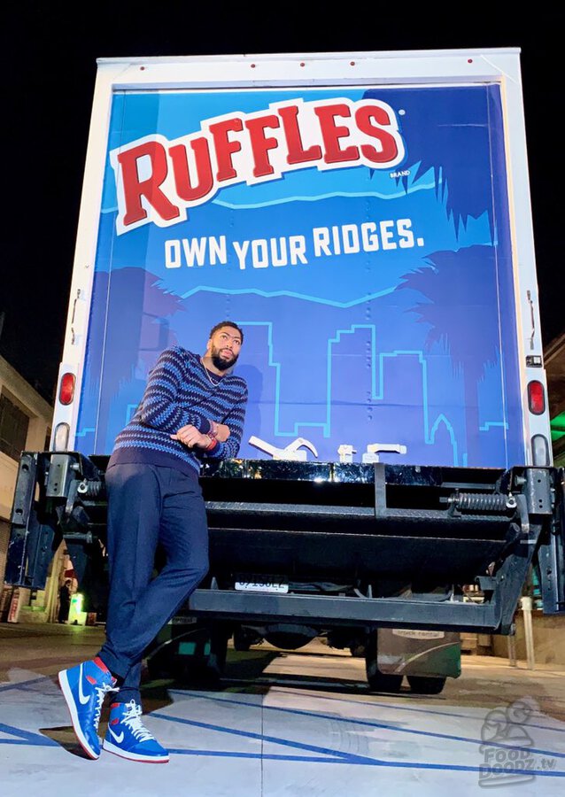 Anthony Davis at Lime & Jalapeno Ruffles chips launch event leaning against Ruffle delivery truck