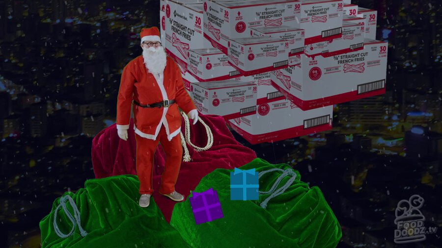 Austin dressed as Santa standing on top of sleigh throwing box of fries off with smoke cloud of boxes appearing behind him