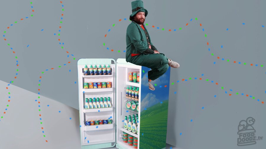 Adam dressed as leprechaun sitting on top of Hidden Valley fridge full of Ranch products